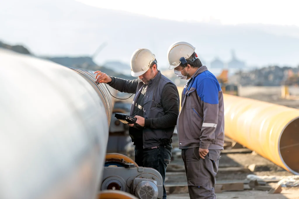 solutions-inspections-two-workers-inspecting-a-large-pipe